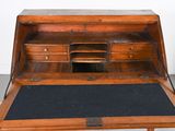 a small wooden desk with a black mat on it