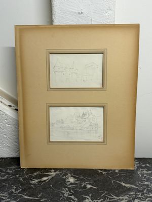 deux dessins encadrés représentant une ville et un bâtiment, posés sur un sol en marbre