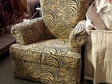 a zebra print chair and ottoman in a warehouse