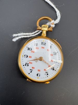 une montre de poche en or suspendue à un cordon