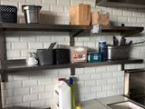a kitchen with a sink, stove, and shelves