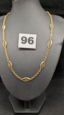 un collier en or exposé, muni d'une étiquette de prix