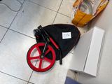 a red wheel on the floor next to a black bag