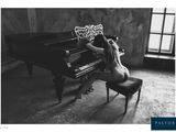 black and white photograph of a naked woman sitting at a piano