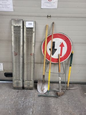 deux pelles et un panneau à côté d'une porte de garage