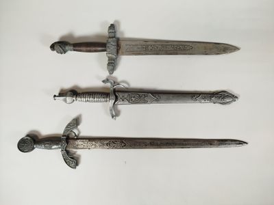 three different types of swords are displayed on a white surface