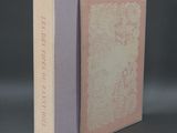 an open book with a pink cover sitting on top of a table