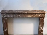 une petite table en bois avec un plateau en marbre, posée à même le sol