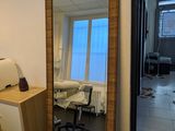 un grand miroir dans un coin de la pièce, à côté d'un bureau