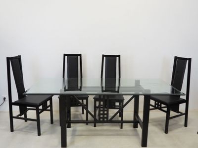 a glass dining table with four chairs around it