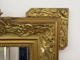 a gold framed mirror on a white wall next to a mirror
