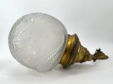 a glass vase with a gold base on a white background