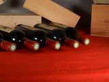 several bottles of wine are lined up on a red table cloth