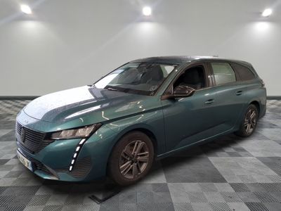the green car is parked on a checkered floor in the garage