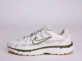La chaussure de course Nike Air Zoom est blanche et verte.
