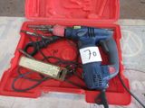 une boîte rouge contenant une perceuse et d'autres outils