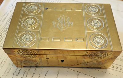 une boîte dorée posée sur une feuille de papier