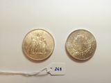 two gold coins with a price tag on a white surface