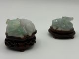deux figurines en jade posées sur un socle en bois
