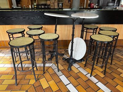 plusieurs tabourets et une table dans une pièce au sol carrelé