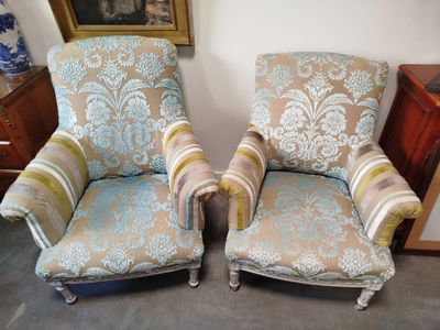 two chairs that are sitting next to each other in a room