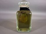 a bottle of perfume with a flower in it on a table