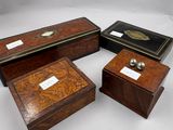 trois boîtes en bois portant des étiquettes, posées sur une surface blanche