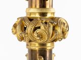 a tall gold vase with a decorative design on it