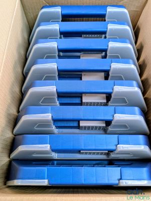 beaucoup de boîtes en plastique bleues dans un carton