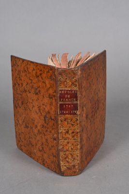 an old book sitting on top of a table next to a gray wall