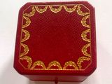 une petite boîte rouge ornée d'un motif doré