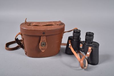 étui à appareil photo en cuir marron avec deux jumelles sur fond blanc