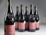 six bottles of wine are lined up in a row on a table