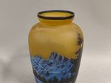 a yellow vase with a picture of a mountain on it