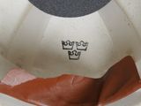 a white bowl with a brown lid and a black lid