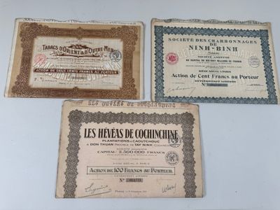 three old certificates are on display on a white surface
