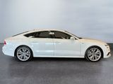 the white audi sedan is parked in a showroom