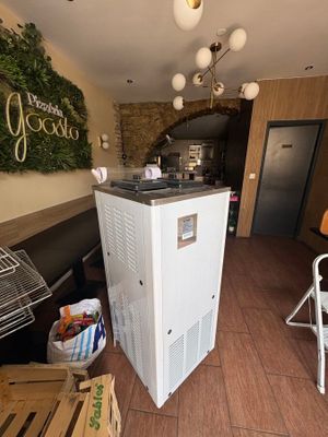 a refrigerator in the middle of a room with a table and chairs