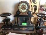 une horloge posée sur une table, à côté d'autres objets