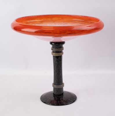 un socle orange et noir surmonté d'un bol en verre