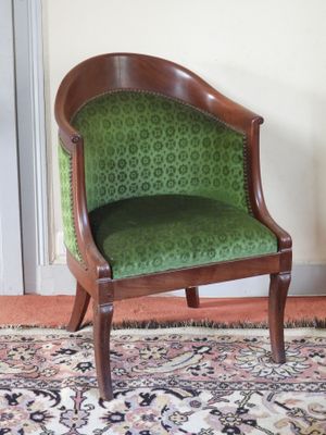 une chaise verte placée dans une pièce où il y a un tapis au sol