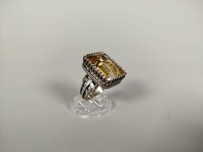 Gros plan sur une bague ornée d'une pierre jaune