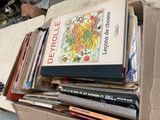 une boîte pleine de livres posée sur le sol