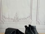 pair of black leather ankle boots on a wooden table