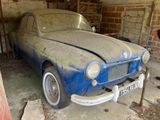 une vieille voiture qui prend la poussière dans un garage