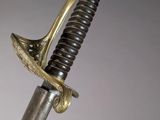 a close up of a sword with a metal handle on a gray background