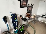 une pièce avec un bureau, un radiateur et des tableaux accrochés au mur