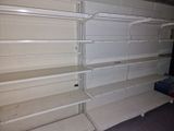many empty shelves in a store with no one on them
