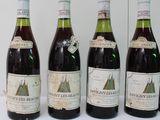 four bottles of wine are lined up on a table