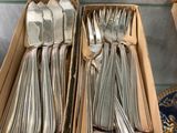 two boxes with silverware in them on a table